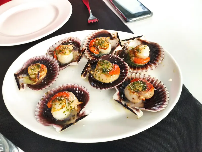 Zamburiñas gratinadas servidas en su concha