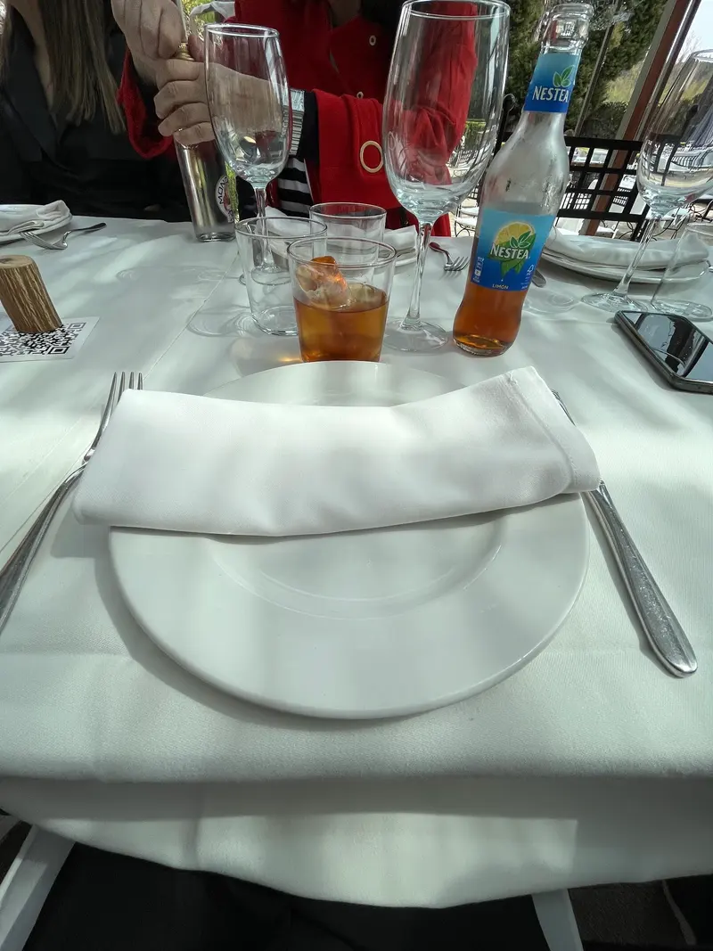 Mesa con mantel blanco, servilleta y copas en la terraza