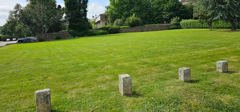 Pradera del jardín con mojones de piedra y árboles al fondo