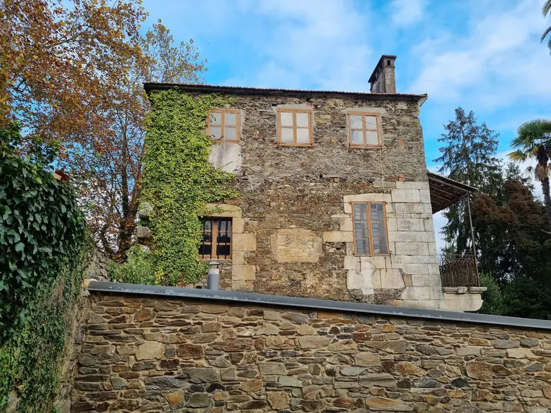 Fachada de piedra del pazo cubierta en parte de hiedra